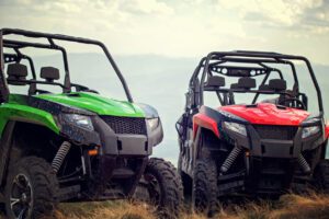 Friends driving off-road with quad bike or ATV and UTV vehicles.